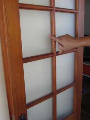 human hand pointing towards wooden door panel glass